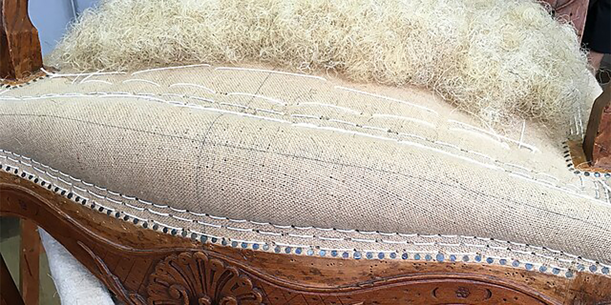 Chaise ancienne en cours de restauration pour une formation spécialisation en tapisserie d'ameublement à l'ÉÉAM, Montréal.